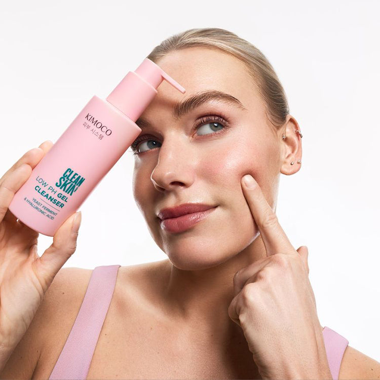 Po środku różowa butelka kosmetyku KImoco Clean Skin Low Ph Gel Cleanser, na białym tle