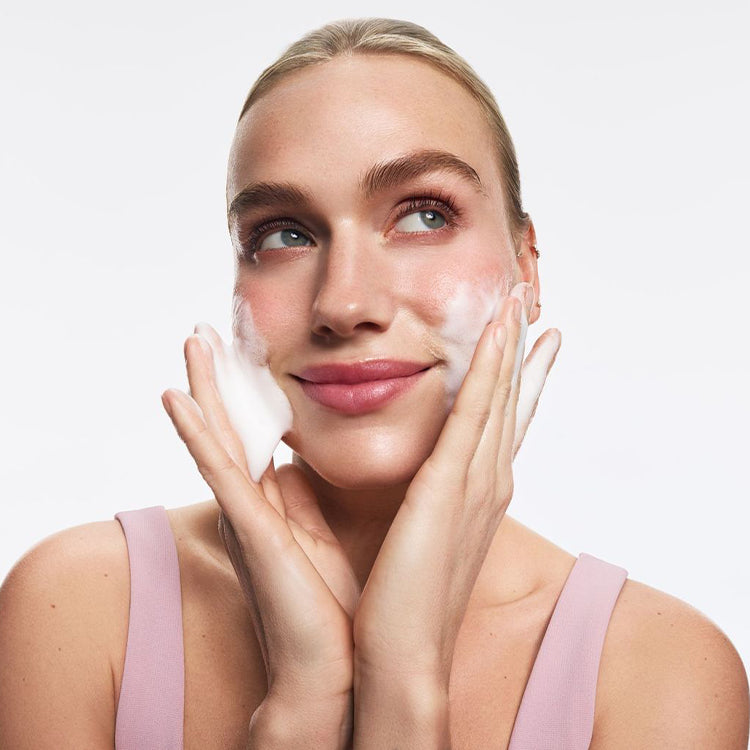 Po środku różowa butelka kosmetyku Kimoco Clean Skin Smoothing Bubble Toner, na białym tle